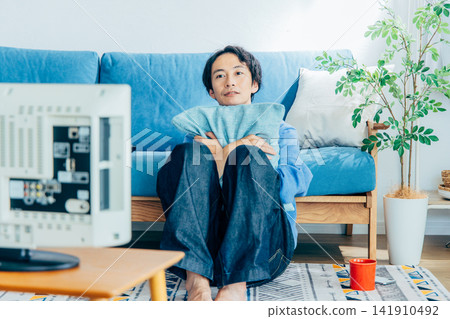 young man watching tv young man watching tv 141910492