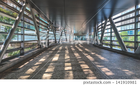 Hong Kong Aug 7 2026 pedestrian footbridge with slatted sunlight shadows Hong Kong Aug 7 2026 pedestrian footbridge with slatted sunlight shadows 141910981