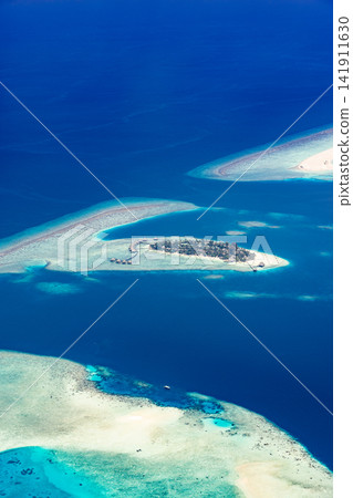 Gorgeous vertical drone view slender sandbank curling into vivid azure lagoon tropical reef. Travel paradise landscape scenic. Exotic getaway portrait wallpaper vista Gorgeous vertical drone view slender sandbank curling into vivid azure lagoon tropical reef. Travel paradise landscape scenic. Exotic getaway portrait wallpaper vista 141911630