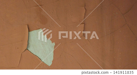 The peeling brown paint reveals a white concrete surface. The peeling brown paint reveals a white concrete surface. 141911835