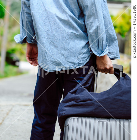 A man walks, pulling a suitcase. A man walks, pulling a suitcase. 141911980
