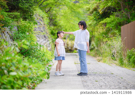 Sisters play in nature, smiling and interacting with each other. Sisters play in nature, smiling and interacting with each other. 141911986