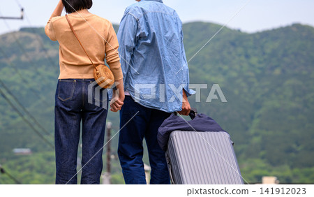 一對情侶手牽手,拉著行李箱,即將出發旅行。 一對情侶手牽手,拉著行李箱,即將出發旅行。 141912023
