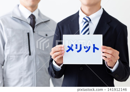身穿西裝的年輕商人,手持一塊印有 Merits 標誌的白板。 身穿西裝的年輕商人,手持一塊印有 Merits 標誌的白板。 141912146