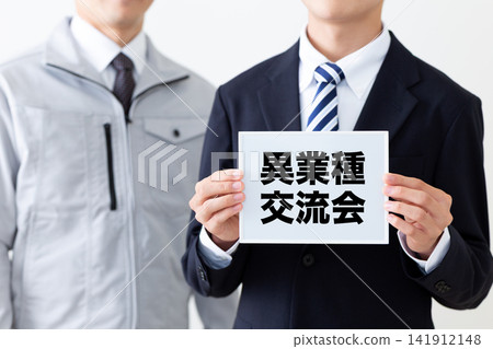 一位身穿西裝的年輕商人手持白板,參加跨產業交流活動。 一位身穿西裝的年輕商人手持白板,參加跨產業交流活動。 141912148