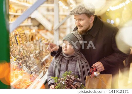 Father and son choosing figurines at the fair Father and son choosing figurines at the fair 141912171