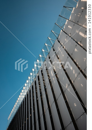 modern building on blue sky background, contemporary artistic architecture of concrete and glass, sharp triangle shapes modern building on blue sky background, contemporary artistic architecture of concrete and glass, sharp triangle shapes 141912330