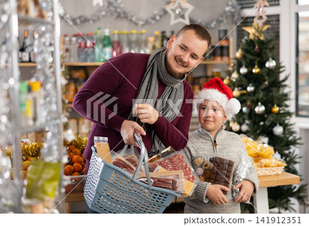 Young man with son choosing products in grocery store Young man with son choosing products in grocery store 141912351