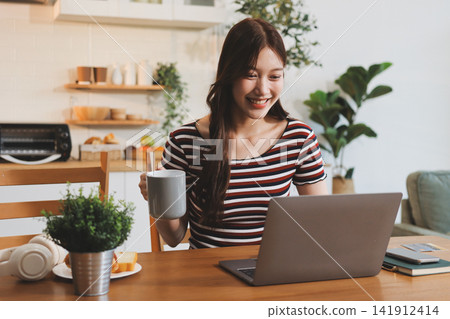 Asian woman using computer remote for business studying, watching online virtual webinar training meeting, video call. asian business woman talking on laptop in home office. Banner, copy space Asian woman using computer remote for business studying, watching online virtual webinar training meeting, video call. asian business woman talking on laptop in home office. Banner, copy space 141912414