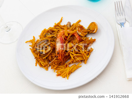 Valencian seafood fideua with shrimp, squid and mussels on plate Valencian seafood fideua with shrimp, squid and mussels on plate 141912668