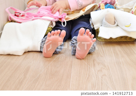 幼兒的腳踩在木地板上；赤腳的孩子在木地板上；兒童房；赤腳的孩子；圖片素材。 141912713