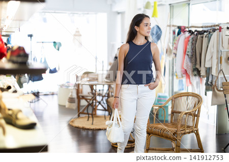 Girl walks through store and chooses something - fashionable clothes and shoes Girl walks through store and chooses something - fashionable clothes and shoes 141912753