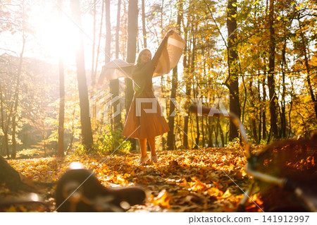 Stylish woman with a bicycle enjoying autumn weather in the park. Beautiful Woman in the autumn forest. Stylish woman with a bicycle enjoying autumn weather in the park. Beautiful Woman in the autumn forest. 141912997