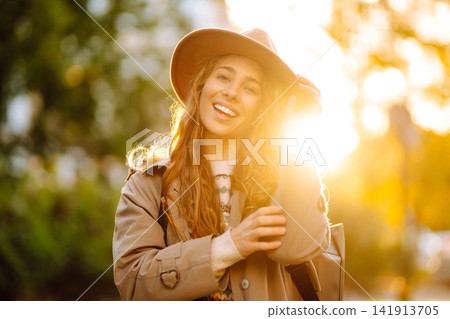 Portrait of a stylish smiling woman walking in park. street style in hat. Concept of nature, relax. 141913705
