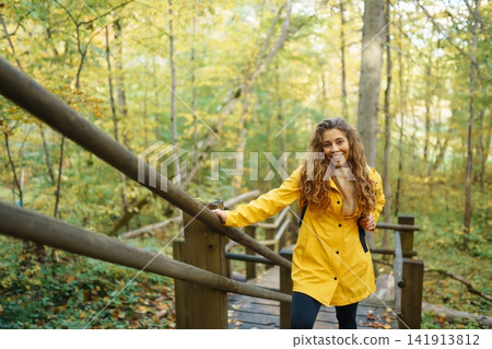 Portrait of young woman walking in the forest. Travelling, lifestyle, adventure. Portrait of young woman walking in the forest. Travelling, lifestyle, adventure. 141913812