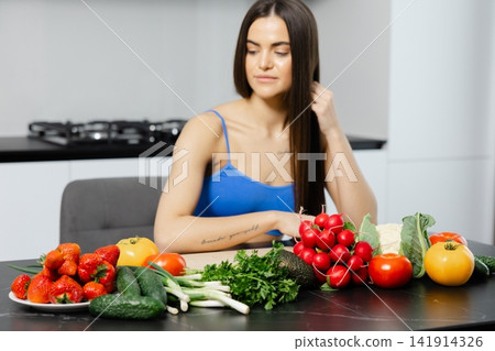 Woman preparing fresh vegetables and fruits for healthy meal Woman preparing fresh vegetables and fruits for healthy meal 141914326