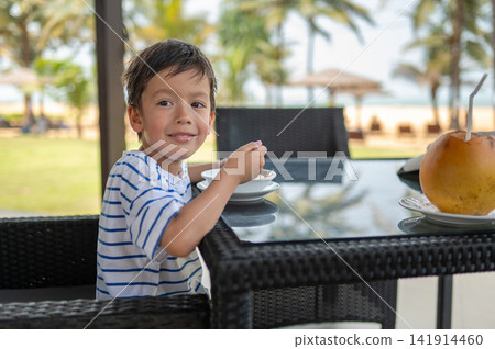 Multiracial boy enjoying breakfast at a seaside cafe in Sri Lanka Multiracial boy enjoying breakfast at a seaside cafe in Sri Lanka 141914460