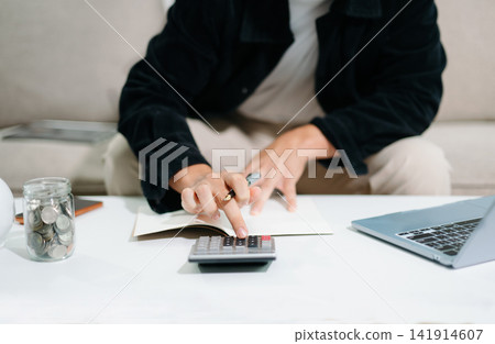 Close up of businesswoman or accountant hand typing laptop working to calculate on desk about cost at home office. Close up of businesswoman or accountant hand typing laptop working to calculate on desk about cost at home office. 141914607