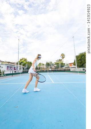 Woman playing tennis on blue court during match Woman playing tennis on blue court during match 141914923