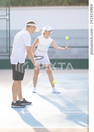 Coach teaching woman how to play tennis Coach teaching woman how to play tennis 141914964