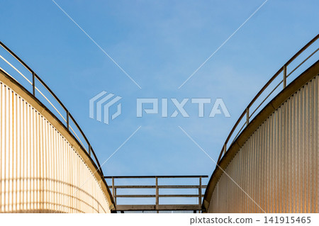 Minimalist industrial architecture with symmetrical storage tanks and catwalk Minimalist industrial architecture with symmetrical storage tanks and catwalk 141915465