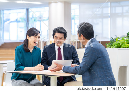 一對中年夫婦正在諮詢理財顧問。拍攝協助單位:電波學園教育基金會、東京電子大學。 一對中年夫婦正在諮詢理財顧問。拍攝協助單位:電波學園教育基金會、東京電子大學。 141915607