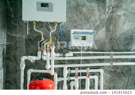 a functional and clean water heater system installed and operational in an indoor residential or commercial setting, viewed from a side perspective at a slight elevation, featuring visible. 141915623