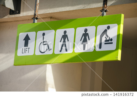 Corby, Northamptonshire, UK - August 2, 2026: Public directional sign indicating lift, accessible facilities, toilets and baby changing area in a shopping centre in Corby, England. Corby, Northamptonshire, UK - August 2, 2026: Public directional sign indicating lift, accessible facilities, toilets and baby changing area in a shopping centre in Corby, England. 141916372