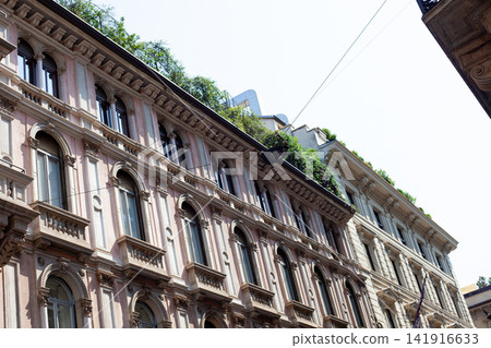 Historic Architecture Facade with Arched Windows and Rooftop Garden in Milan Center City Italy Historic Architecture Facade with Arched Windows and Rooftop Garden in Milan Center City Italy 141916633