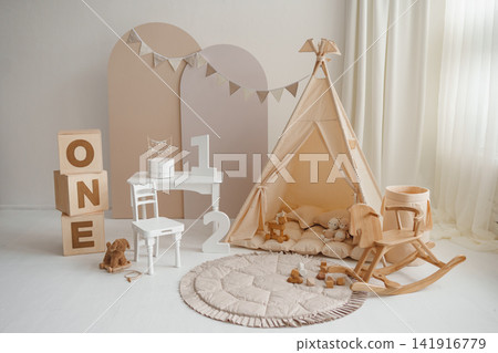 Boho first birthday photo zone with beige teepee, wooden rocking horse and white cake table Boho first birthday photo zone with beige teepee, wooden rocking horse and white cake table 141916779
