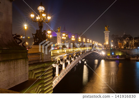 Illuminated Historic Bridge Over the Seine River at Night in Paris, France Illuminated Historic Bridge Over the Seine River at Night in Paris, France 141916830
