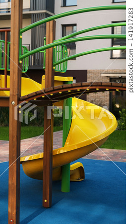 Playground structure with spiral slide and bright colors in a residential area, bringing concepts of childhood fun and leisure Playground structure with spiral slide and bright colors in a residential area, bringing concepts of childhood fun and leisure 141917283