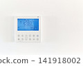 Digital air conditioner thermostat panel on white wall displaying 141918002