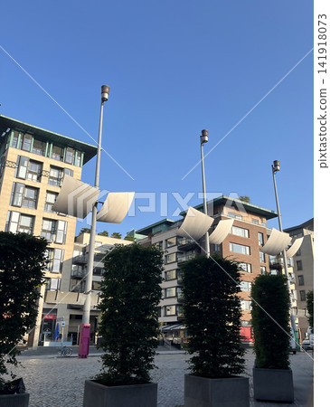 Modern urban architecture of Aker Brygge in Oslo featuring residential buildings, unique sail-shaped street lights Modern urban architecture of Aker Brygge in Oslo featuring residential buildings, unique sail-shaped street lights 141918073