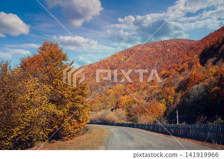 Driving a car along a mountain winding road. Empty road. View from a car to the autumn mountain landscape Driving a car along a mountain winding road. Empty road. View from a car to the autumn mountain landscape 141919966
