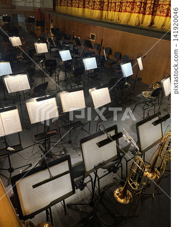 The orchestra pit in the theater. Sheet music, musical instruments. Vertical photo The orchestra pit in the theater. Sheet music, musical instruments. Vertical photo 141920046