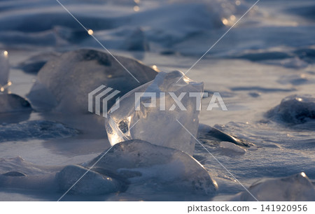 貝加爾湖透明的浮冰在冬日低垂的陽光下閃閃發光。 貝加爾湖透明的浮冰在冬日低垂的陽光下閃閃發光。 141920956