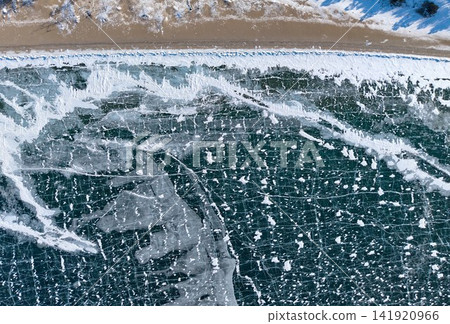 Aerial view of the transparent, cracked ice spreading along the shore of Lake Baikal. Aerial view of the transparent, cracked ice spreading along the shore of Lake Baikal. 141920966