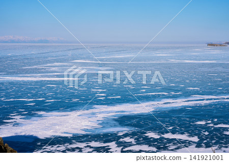 Frozen Lake Baikal with its snow-covered patches and distant mountain ranges. Frozen Lake Baikal with its snow-covered patches and distant mountain ranges. 141921001