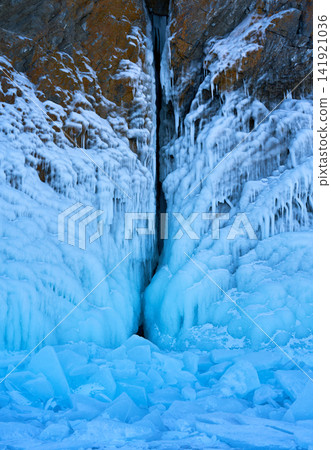 Blue ice covering deep crevices in the rock face, Lake Baikal in winter. Blue ice covering deep crevices in the rock face, Lake Baikal in winter. 141921036