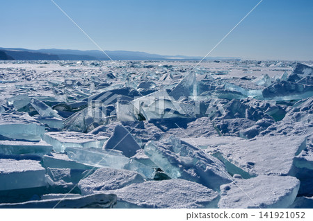 The frozen Lake Baikal, with its chains of transparent ice floes, and the distant mountain range. The frozen Lake Baikal, with its chains of transparent ice floes, and the distant mountain range. 141921052
