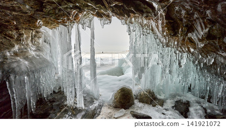 Lake Baikal in winter, viewed from behind an icicle-covered rock. Lake Baikal in winter, viewed from behind an icicle-covered rock. 141921072