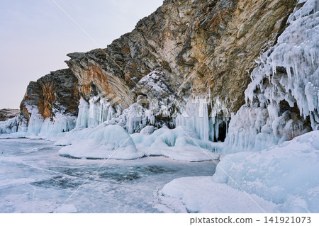 Rock faces dotted with ice formations and the frozen shores of Lake Baikal Rock faces dotted with ice formations and the frozen shores of Lake Baikal 141921073