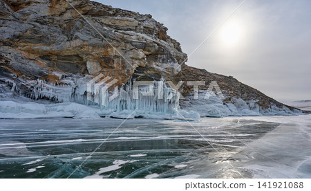 Icicle-covered rock faces and Lake Baikal illuminated by winter sunlight Icicle-covered rock faces and Lake Baikal illuminated by winter sunlight 141921088