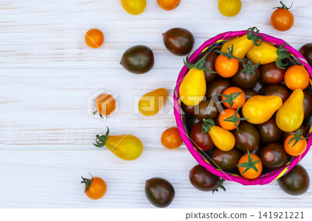 Colorful organic cherry tomatoes on the white wooden table. Colorful organic cherry tomatoes on the white wooden table. 141921221