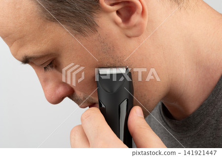 Young man trim his beard 141921447