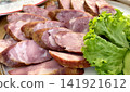 sliced homemade sausage on plate with lettuce leaf rustic food close up  141921612