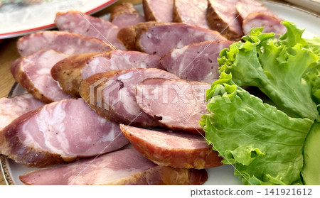 sliced homemade sausage on plate with lettuce leaf rustic food close up sliced homemade sausage on plate with lettuce leaf rustic food close up 141921612
