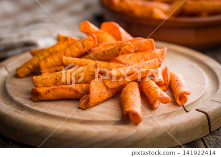 Spicy Rolled Corn Chips On Wooden Board Close-Up - Seasoned Crispy Snack For Parties Spicy Rolled Corn Chips On Wooden Board Close-Up - Seasoned Crispy Snack For Parties 141922414
