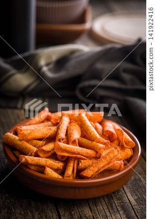 Spicy Rolled Corn Snacks in Bowl . Crunchy Red Chili Snack Chips for Party or Snack Time Spicy Rolled Corn Snacks in Bowl . Crunchy Red Chili Snack Chips for Party or Snack Time 141922416